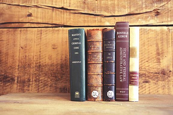 older books arranged against a wood backdrop